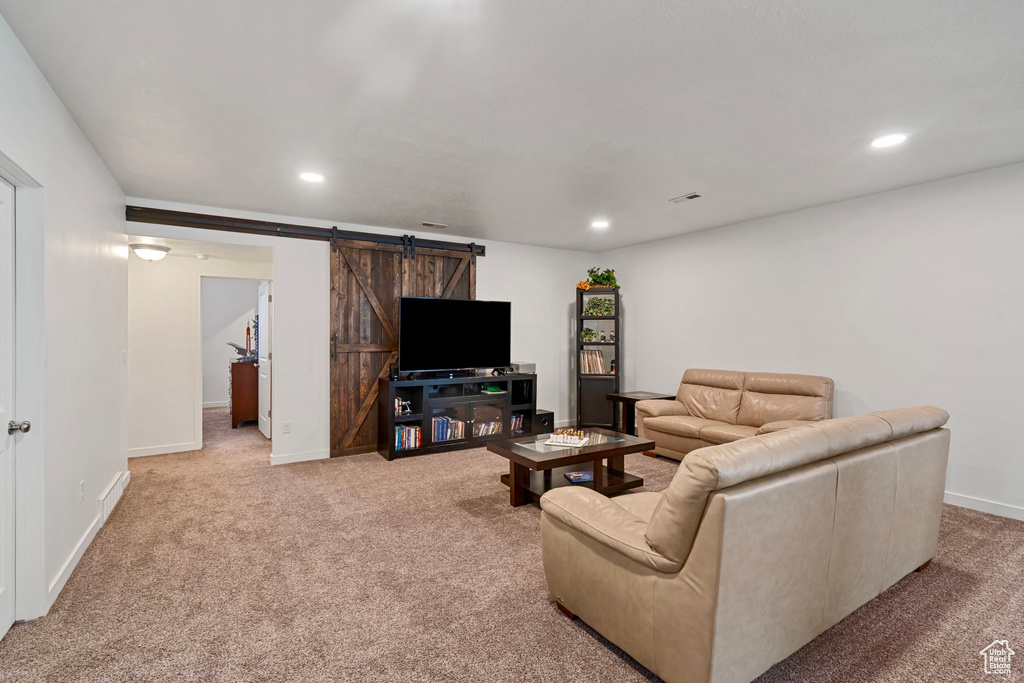 Living room featuring recessed lighting, a barn door, and carpet flooring