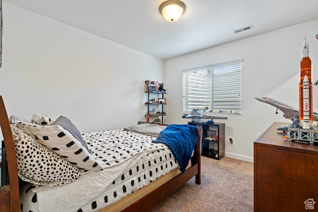Bedroom featuring baseboards, visible vents, and carpet