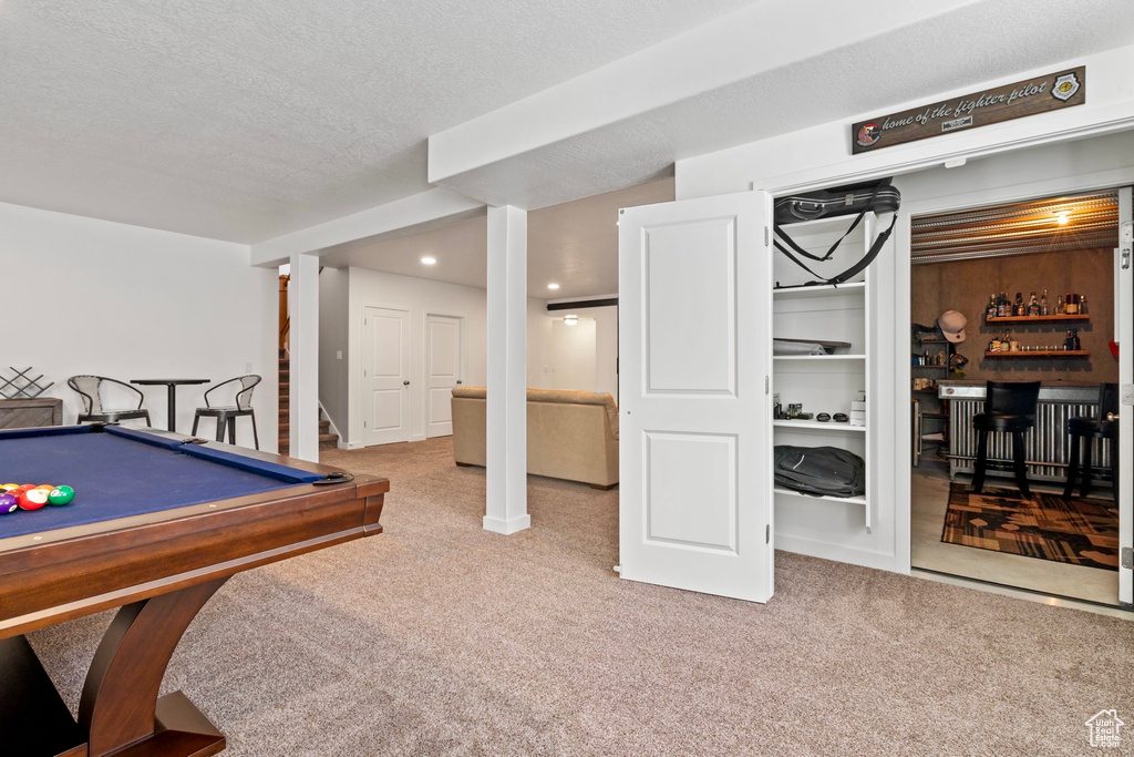 Playroom featuring a bar, carpet flooring, a textured ceiling, and pool table