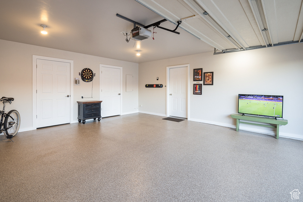 Garage featuring baseboards and a garage door opener