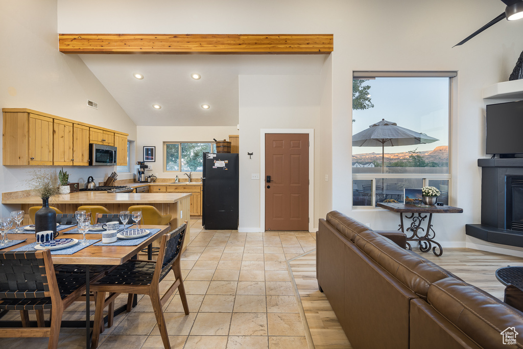 Kitchen with a sink, freestanding refrigerator, open floor plan, stainless steel microwave, and visible vents