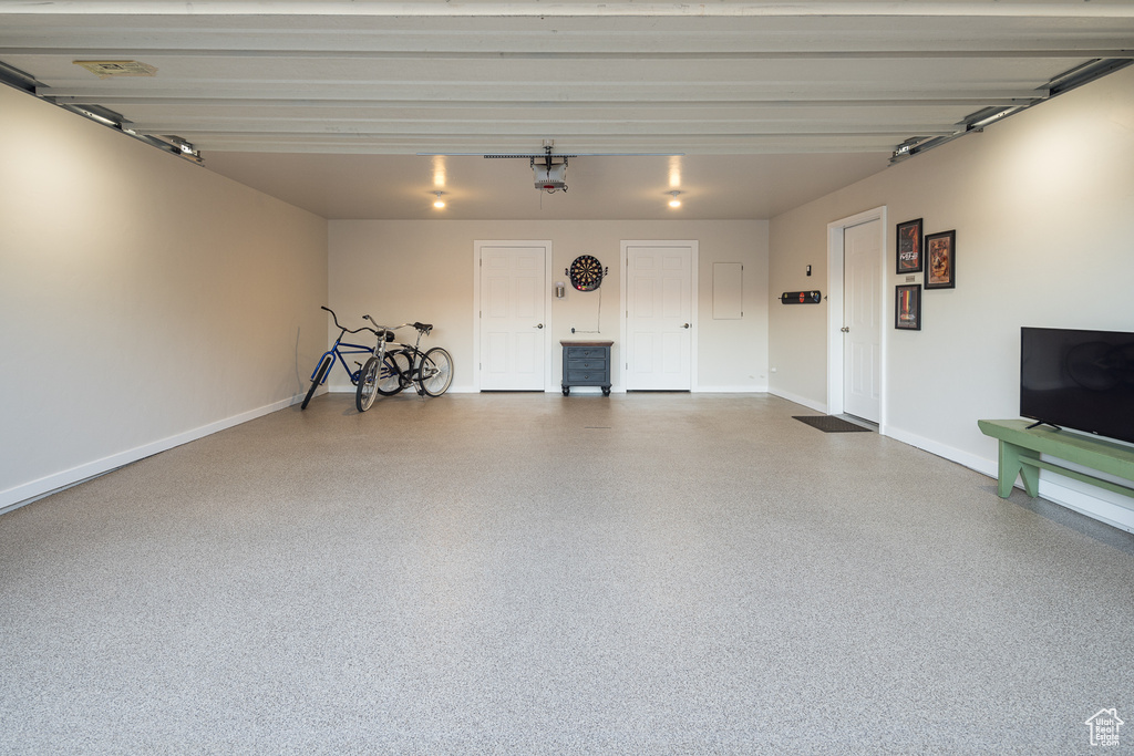 Garage with baseboards and a garage door opener