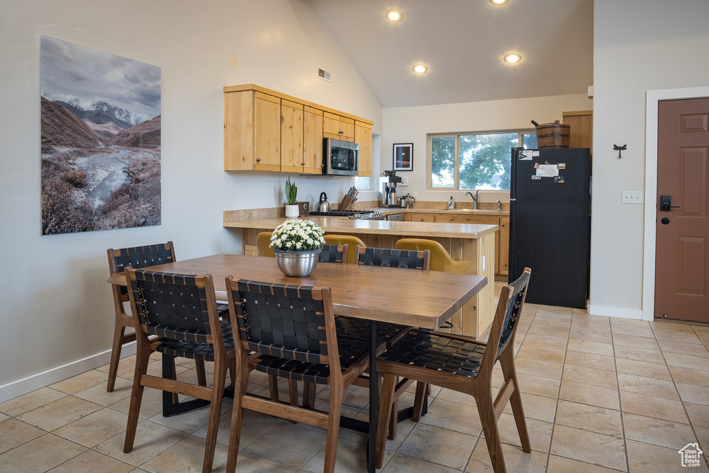 Dining area with baseboards, high vaulted ceiling, visible vents, and light tile patterned floors
