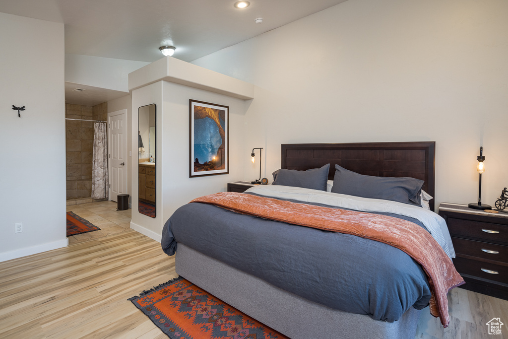 Bedroom with baseboards, ensuite bathroom, recessed lighting, and light wood finished floors
