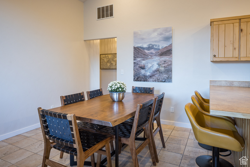 Dining room with baseboards, visible vents, and light tile patterned flooring