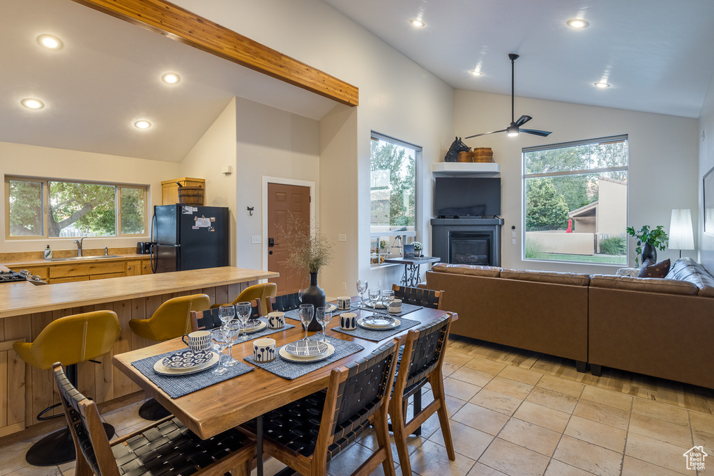 Dining space with lofted ceiling, a glass covered fireplace, recessed lighting, and a ceiling fan