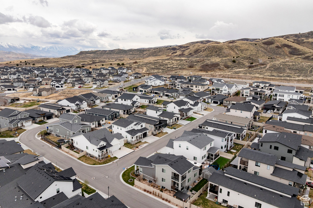 Aerial view of property and surrounding area with mountains and nearby suburban area