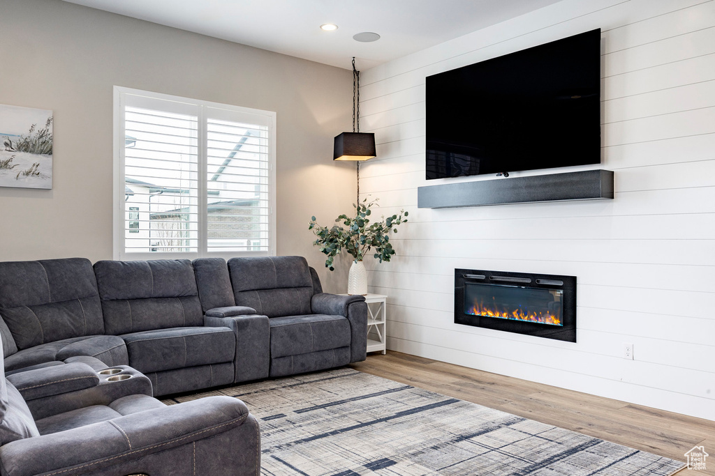 Living area with recessed lighting, a large fireplace, and wood finished floors