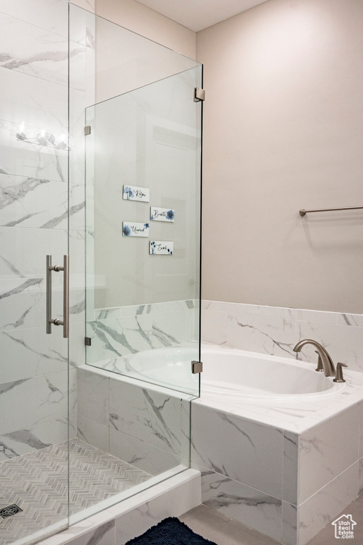 Bathroom featuring a marble finish shower and a garden tub