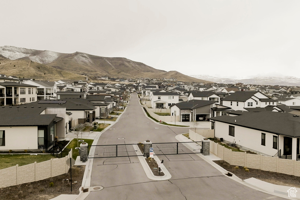 View of street with a gated entry, a mountain view, and a residential view