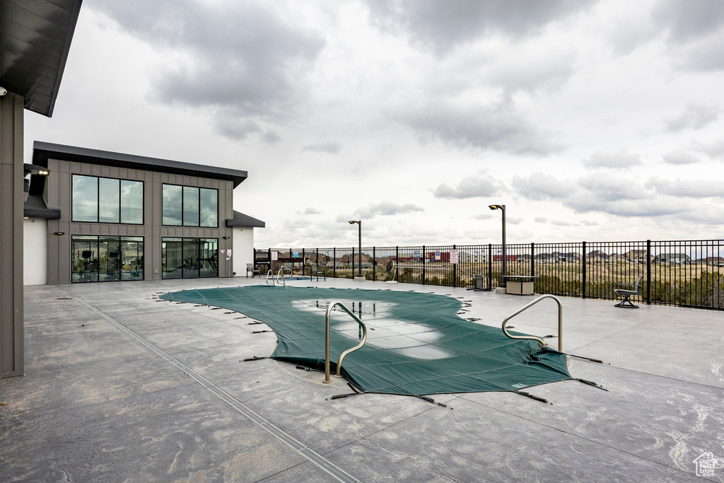 Community pool with a patio and fence