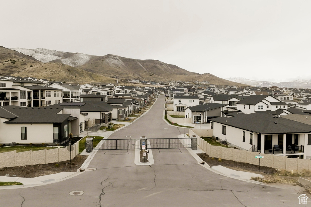 Exterior space featuring a residential view, sidewalks, a gated entry, curbs, and a mountain view