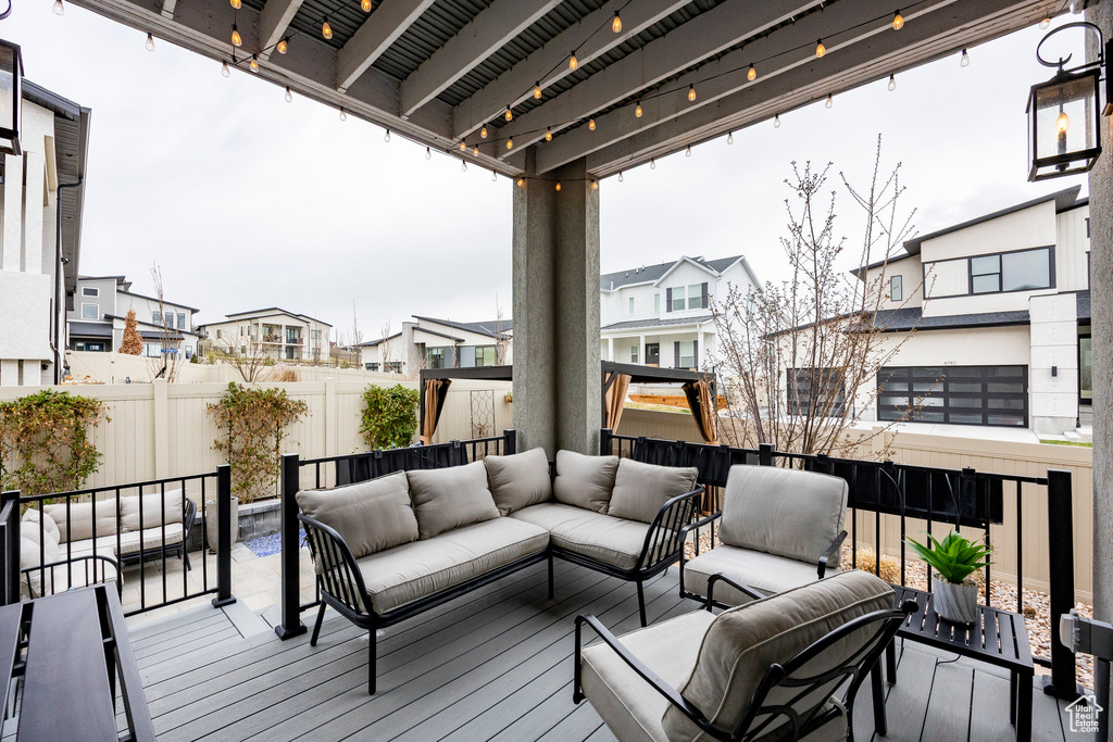 Wooden terrace with an outdoor living space, a residential view, and a fenced backyard