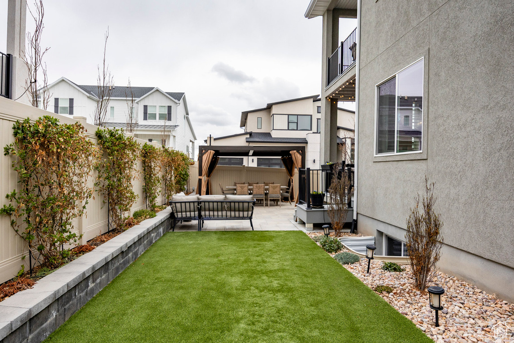 View of yard featuring a patio, a fenced backyard, an outdoor hangout area, and a gazebo