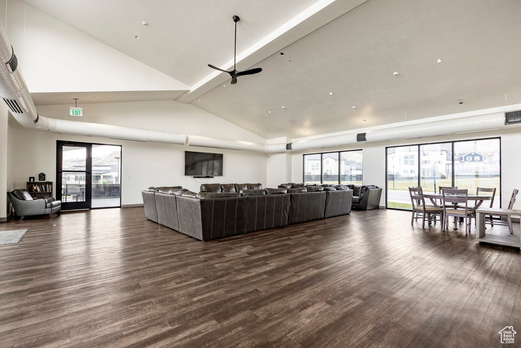 Living room with high vaulted ceiling, ceiling fan, wood finished floors, and visible vents