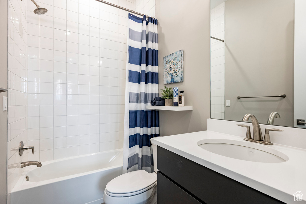 Full bath with vanity, toilet, and shower / tub combo with curtain