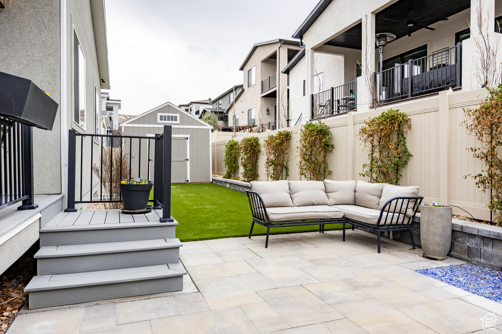View of patio / terrace with a storage shed, an outdoor living space, an outbuilding, and a fenced backyard