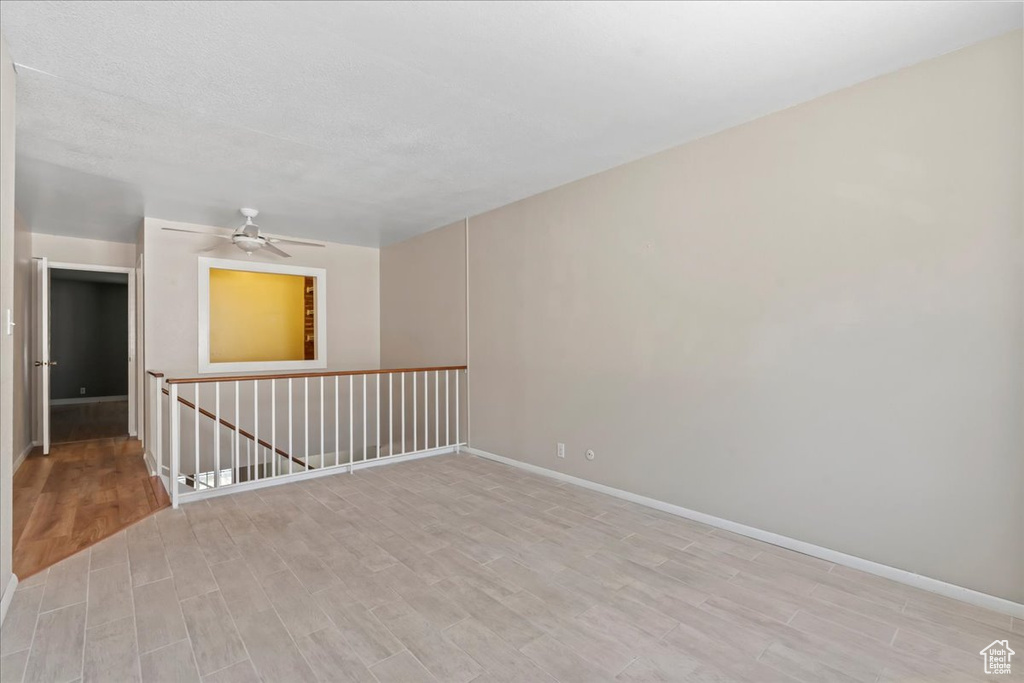 Unfurnished room featuring light wood-style flooring, baseboards, and a ceiling fan