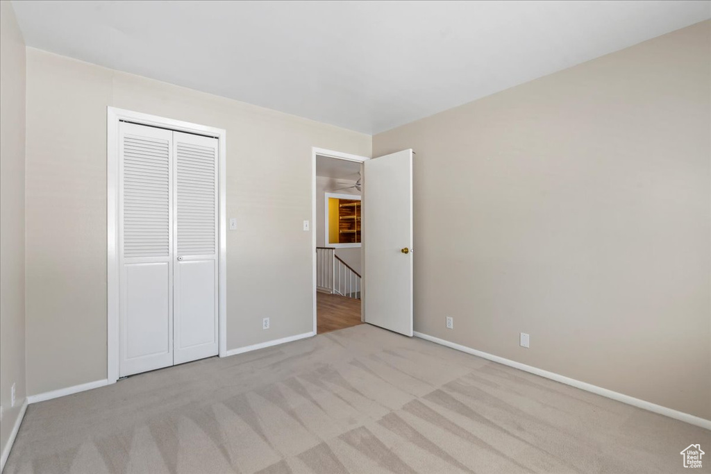 Unfurnished bedroom featuring carpet flooring, baseboards, and a closet
