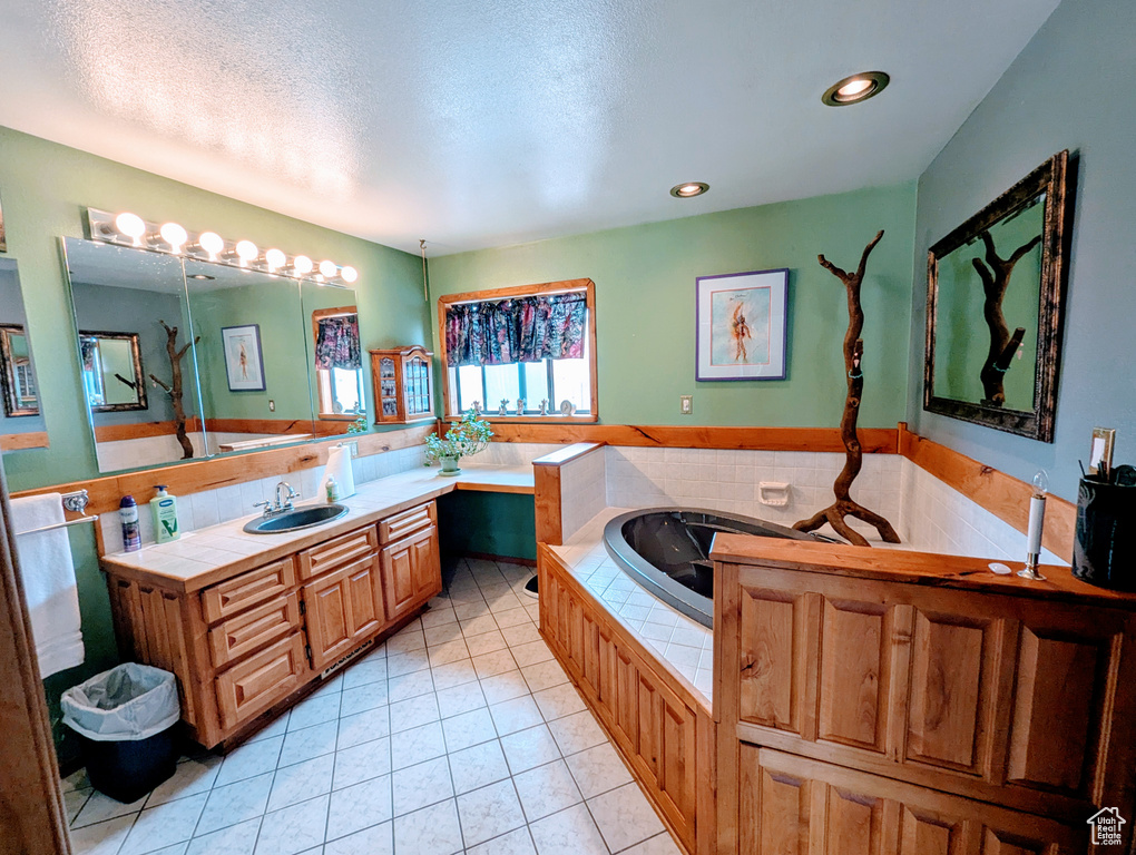 Bathroom with tile patterned flooring, vanity, recessed lighting, a textured ceiling, and a bath