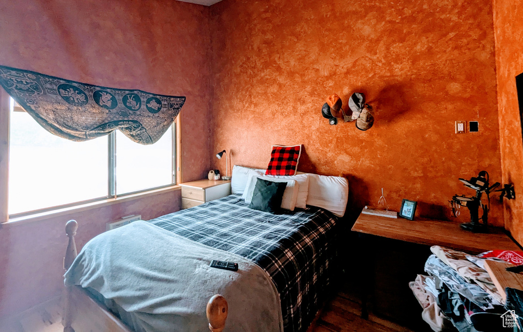 Bedroom featuring wood finished floors and multiple windows