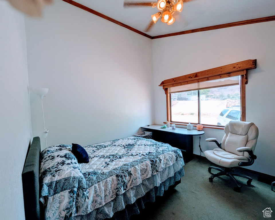 Bedroom with a ceiling fan, baseboards, ornamental molding, and carpet