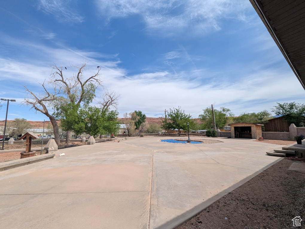 View of patio with a fenced in pool, a garage, fence, and an outbuilding