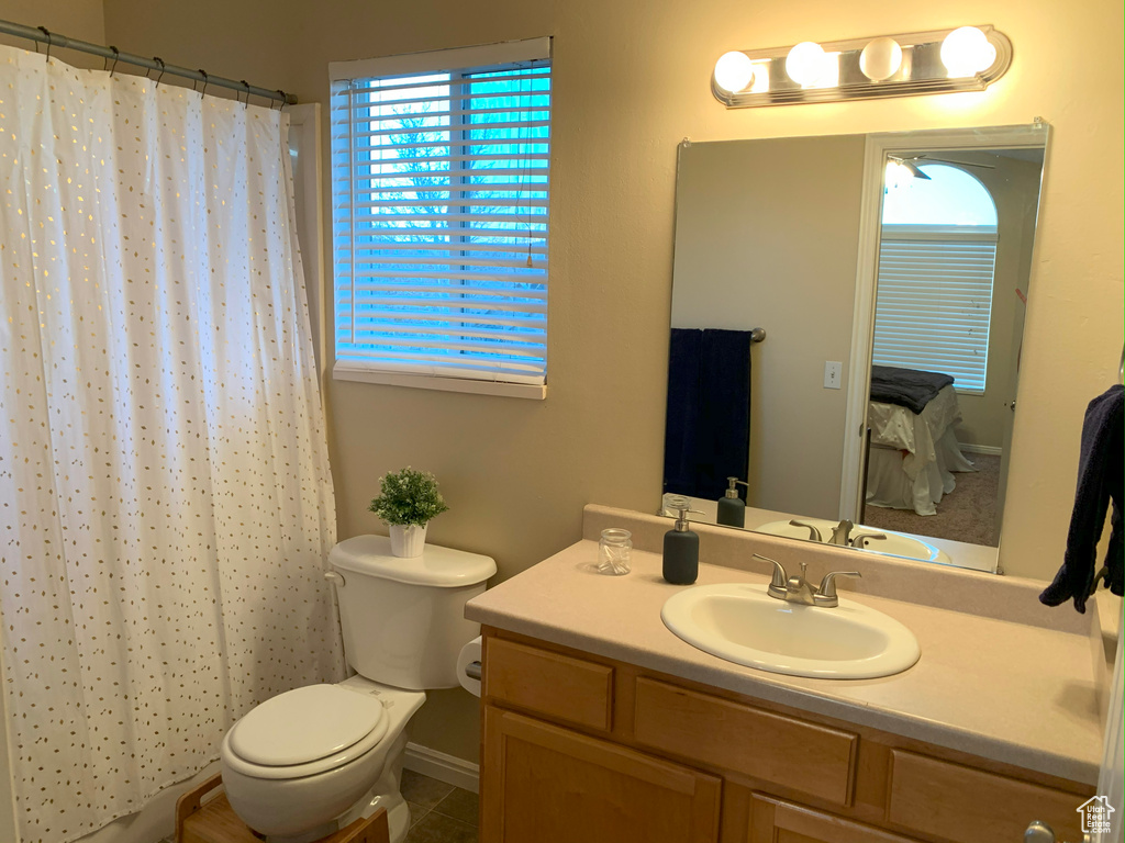 Full bath with toilet, a shower with shower curtain, and vanity
