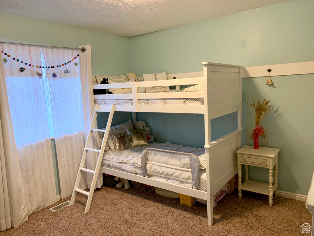 Bedroom with carpet flooring and a textured ceiling