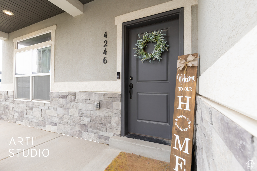 Entrance to property with stone siding and stucco siding