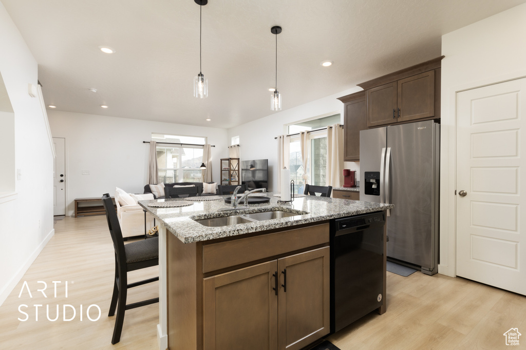 Kitchen featuring black dishwasher, a sink, stainless steel fridge with ice dispenser, and a healthy amount of sunlight