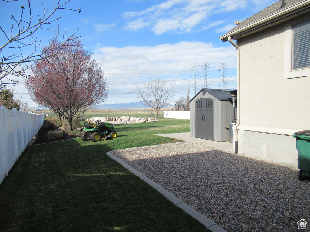 View of yard with an outbuilding, a storage unit, and a fenced backyard