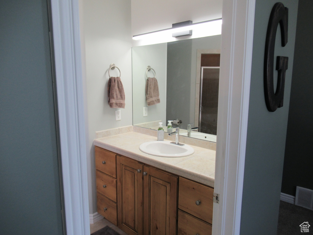 Full bath featuring visible vents, an enclosed shower, and vanity