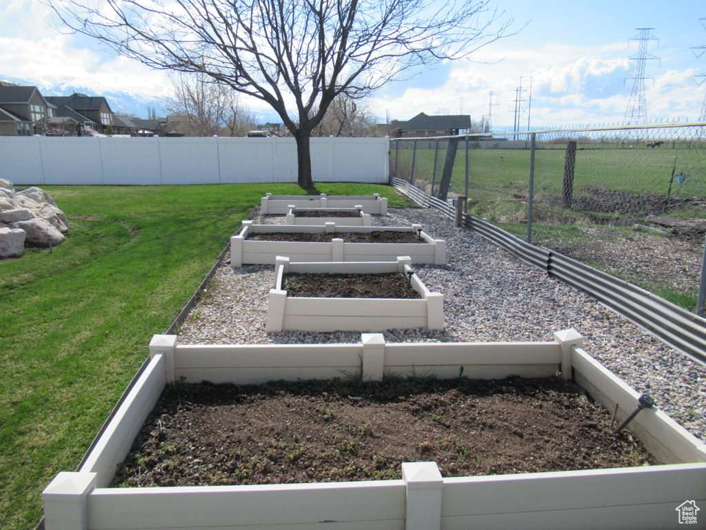 View of yard featuring fence and a vegetable garden