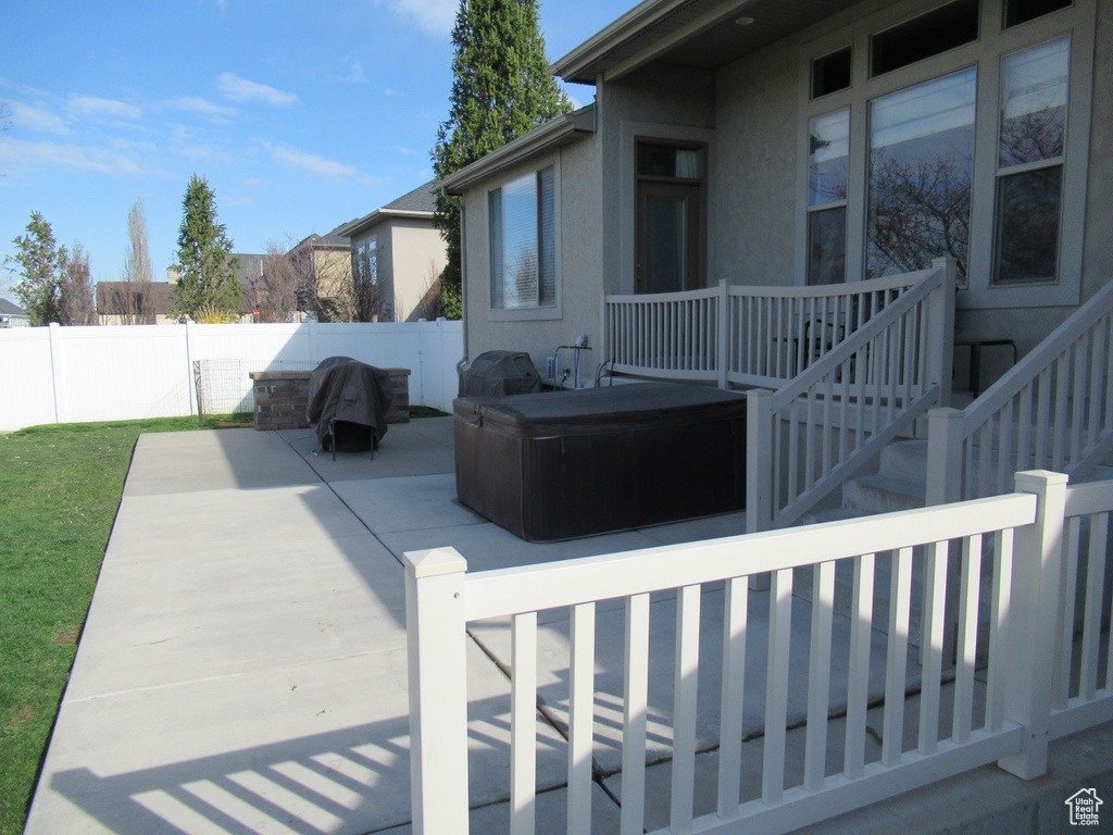 View of patio featuring a hot tub and a fenced backyard
