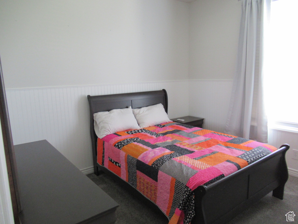 Bedroom with a wainscoted wall and carpet floors
