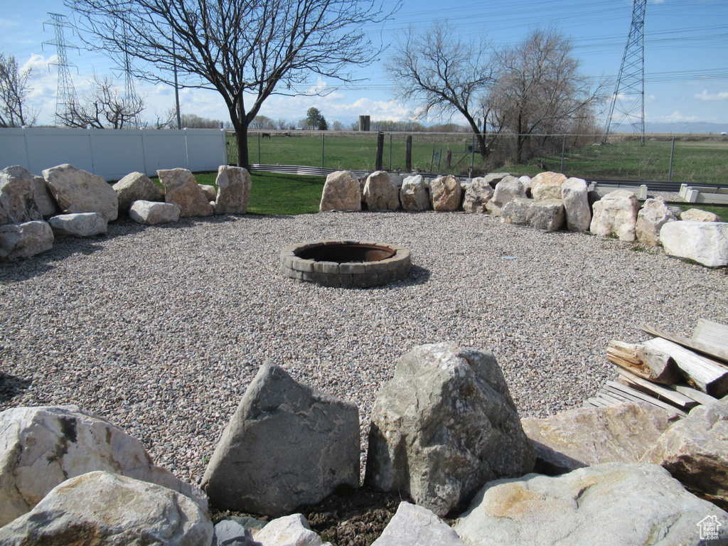 View of yard with fence and a fire pit