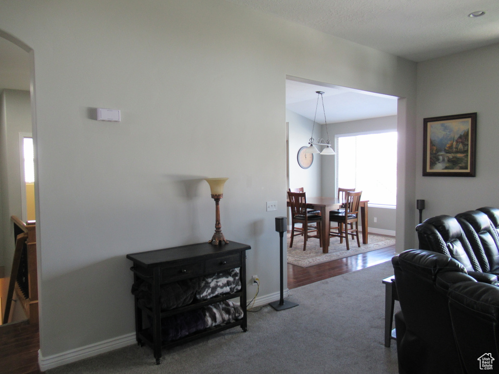 Living room featuring baseboards, arched walkways, and carpet