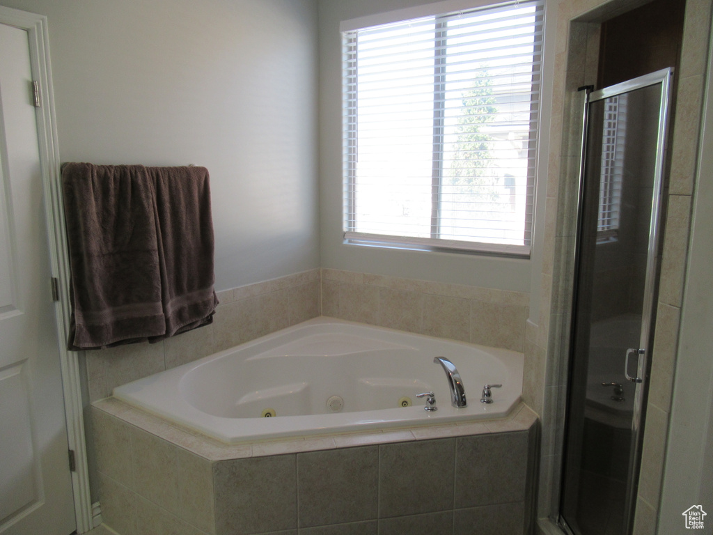 Bathroom featuring a stall shower and a jetted tub