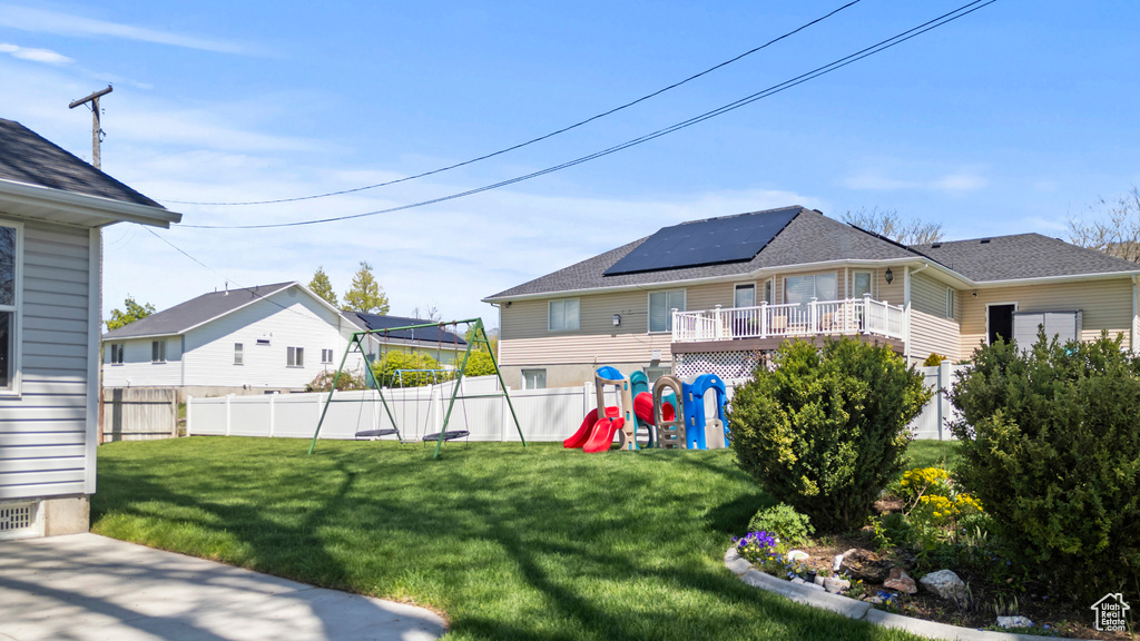 View of yard with a playground and a deck