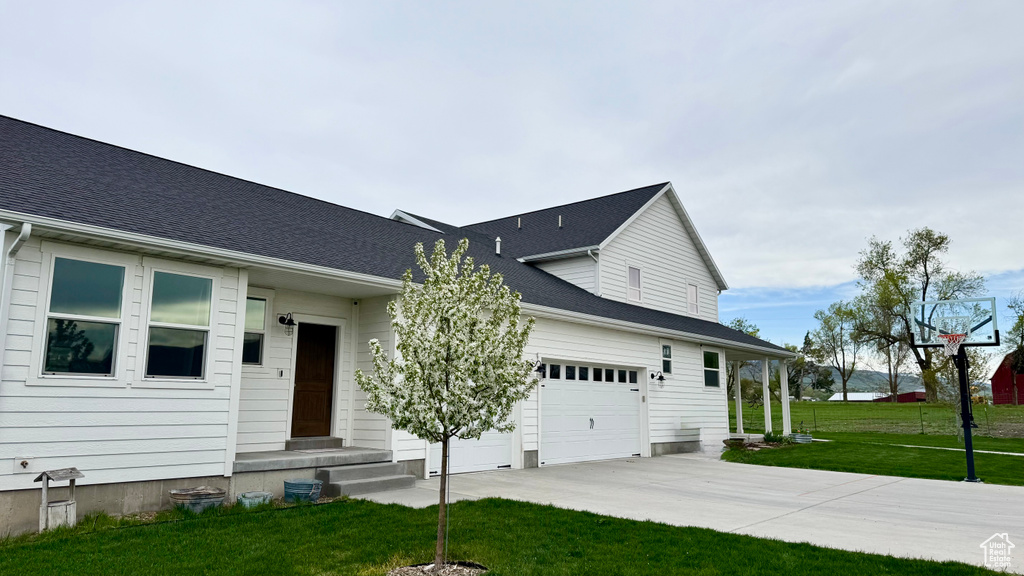 View of front of house featuring a front yard, driveway, and an attached garage