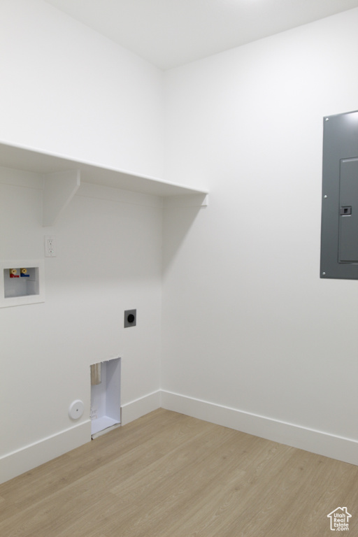 Laundry room with gas dryer hookup, light wood-style flooring, electric panel, hookup for a washing machine, and laundry area
