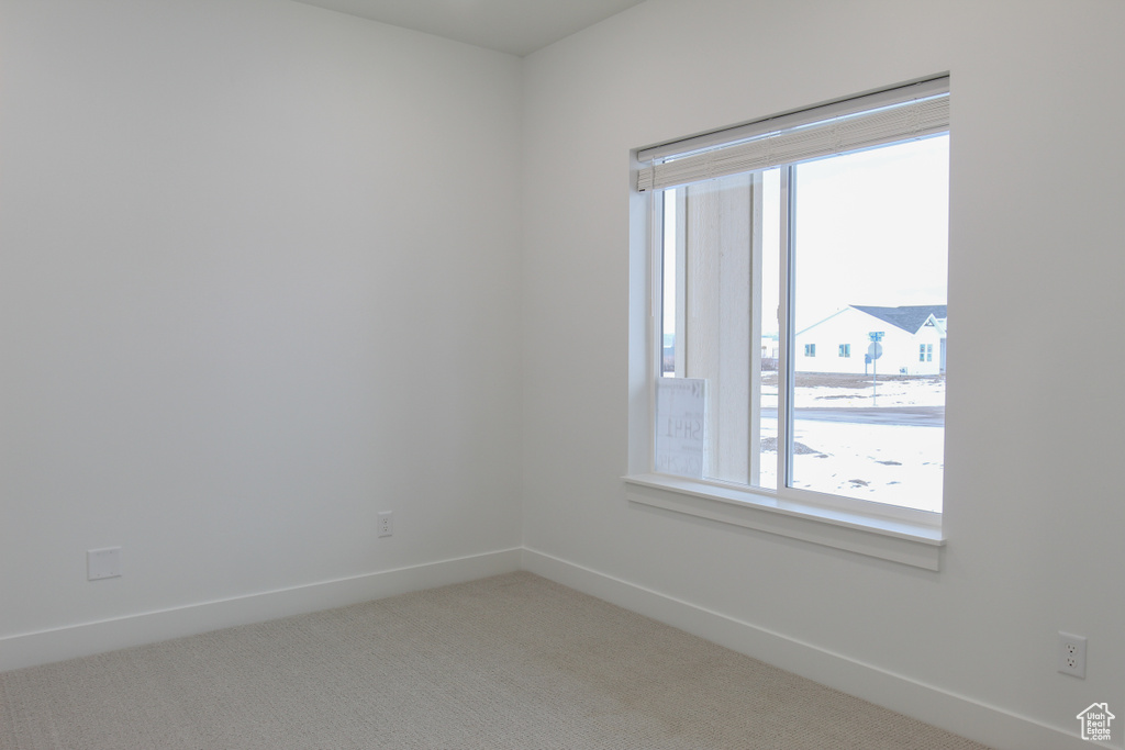 Empty room featuring light carpet and baseboards