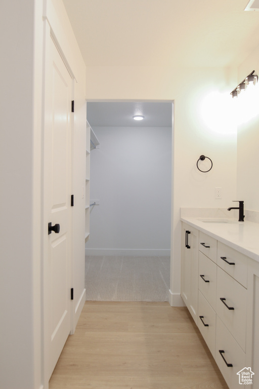 Bathroom with baseboards, wood finished floors, and vanity