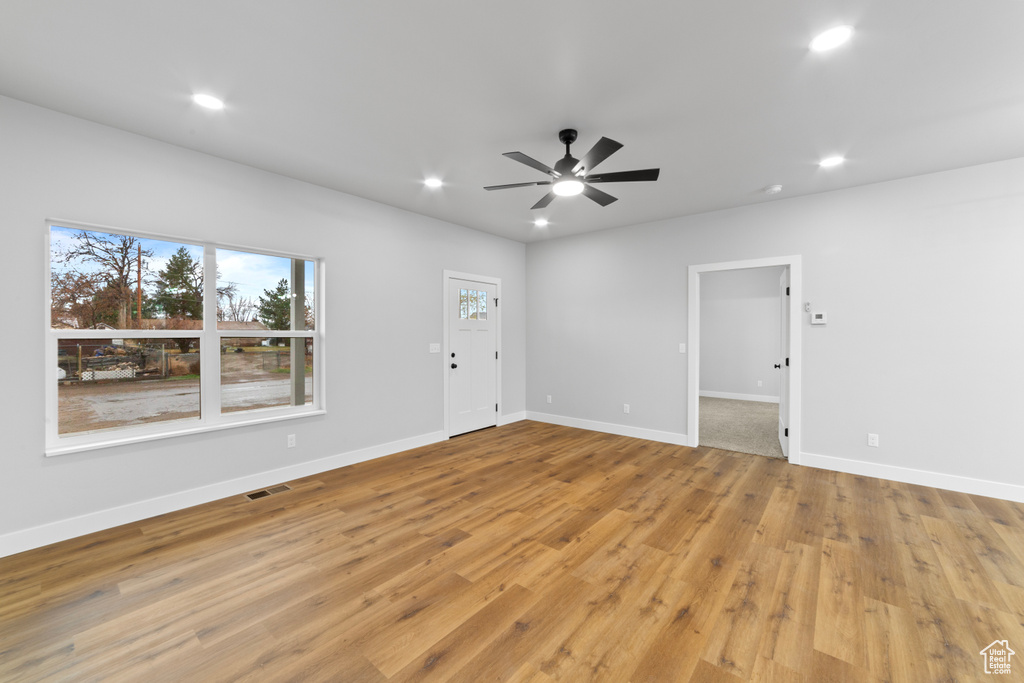 Empty room with ceiling fan, light wood-style flooring, and recessed lighting