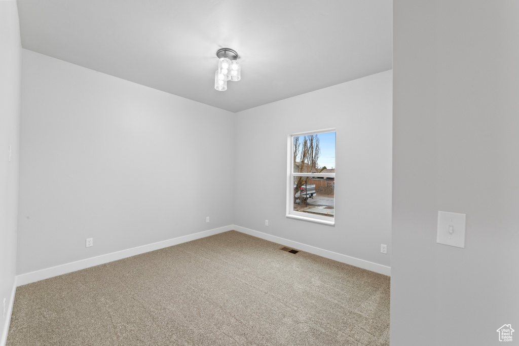 Empty room featuring baseboards, visible vents, and carpet