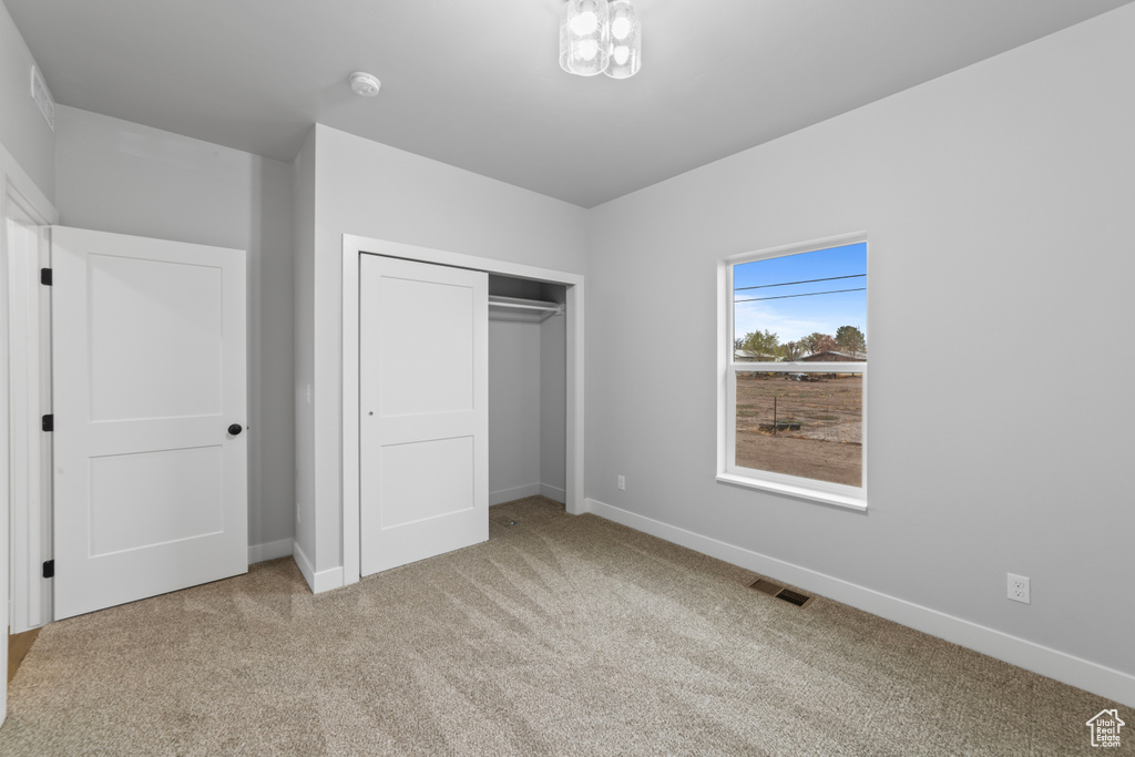 Unfurnished bedroom with baseboards, visible vents, a closet, and carpet floors