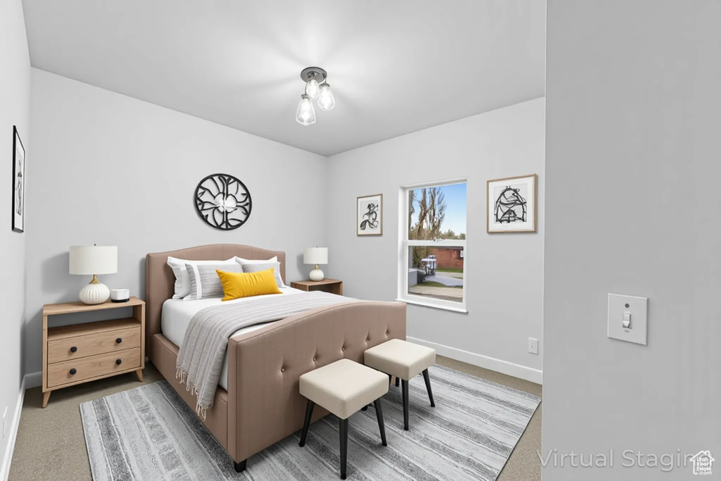 Bedroom with light colored carpet and baseboards