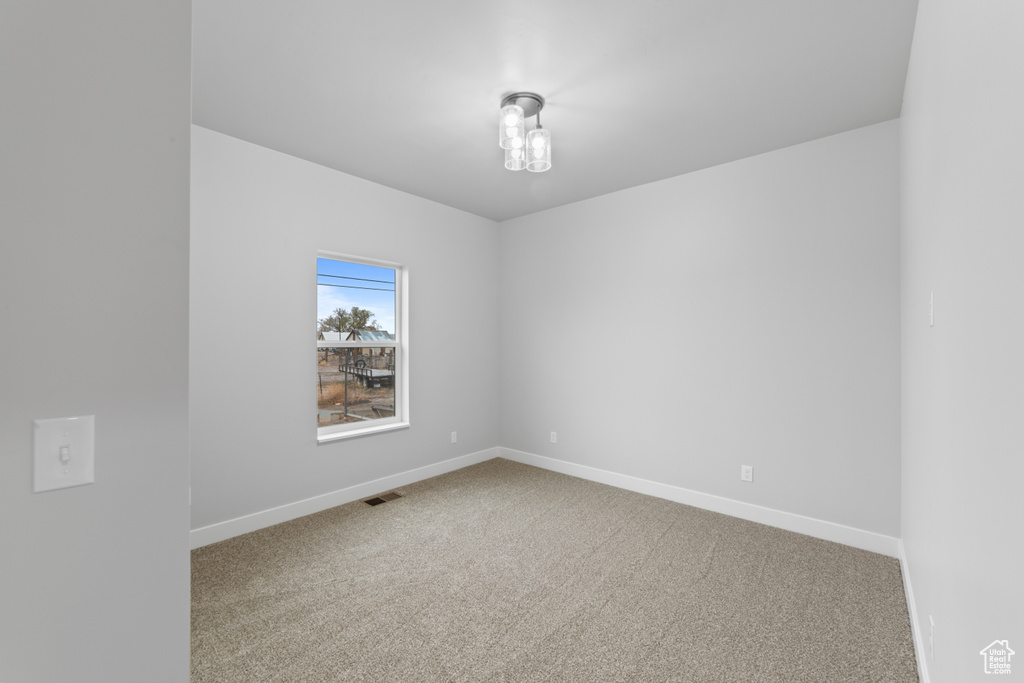 Carpeted spare room with baseboards and visible vents