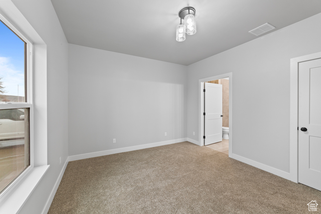Empty room with baseboards, carpet floors, and visible vents